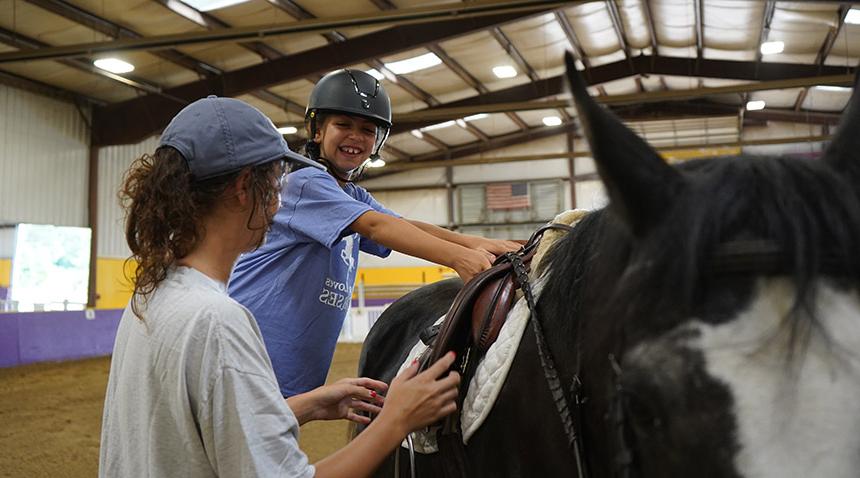 student on a horse with an instructor beside them